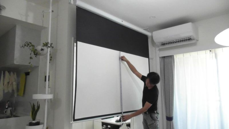 プロジェクタースクリーンの動作と視聴位置を確認する様子
